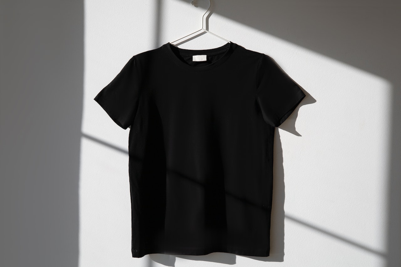 A black t-shirt hanging on a hanger ready for digital textile printing