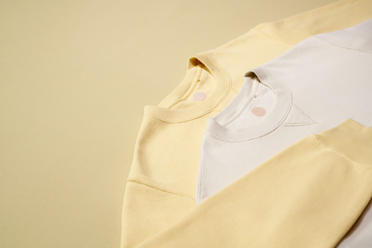 A yellow and white jumper ready to have new labels sewn in after choosing between direct to Garment or Heat Transfer printing on the labels