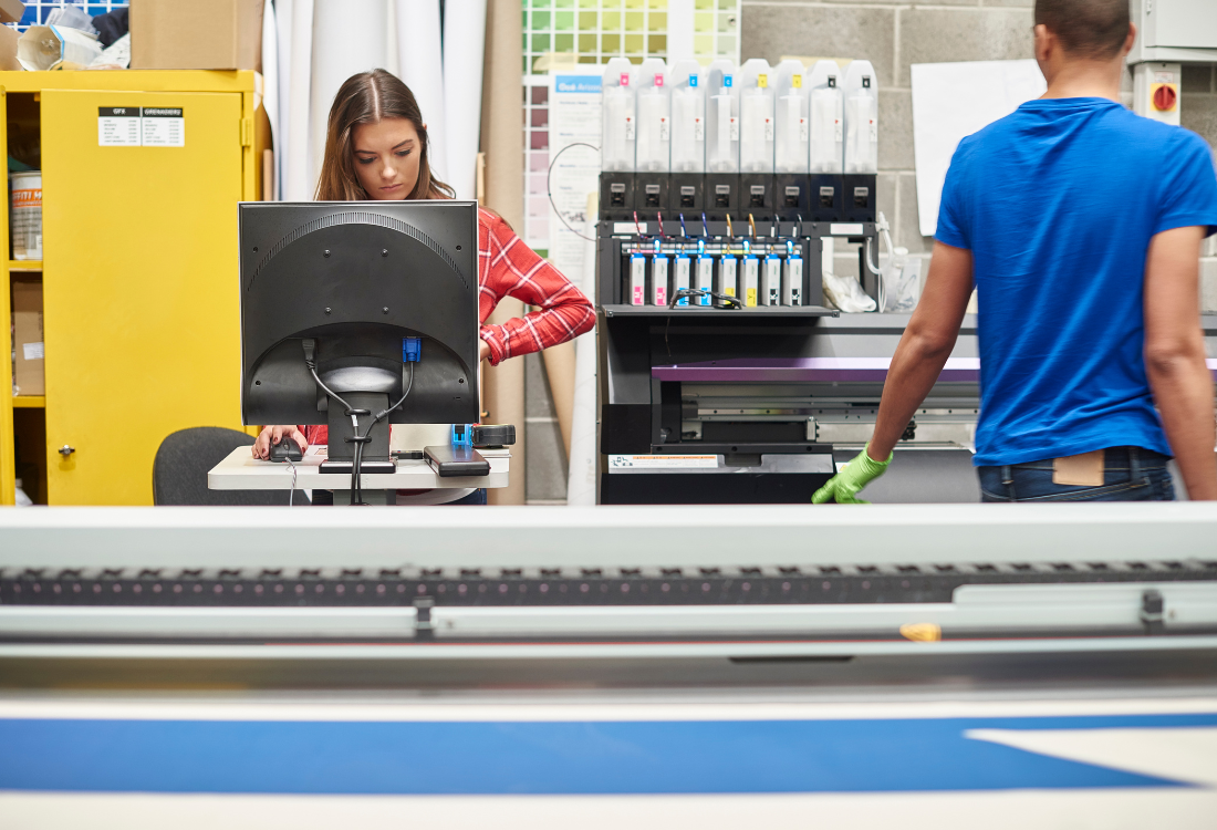 A woman using a digital inkjet machine for label printing.