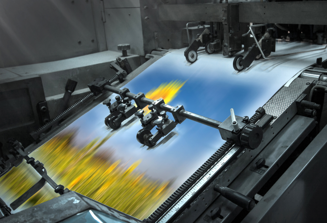 A digital printing press in operation producing colourful prints, representing sustainable and energy-efficient printing technology.